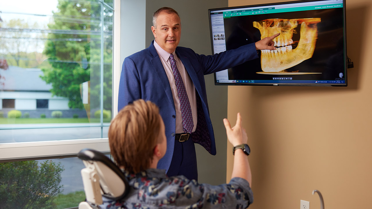 Dr. Andrew J. Dvonch explaining an x-ray to a patient